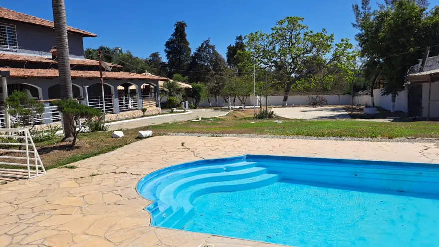 Piscina com o alojamento ao fundo, em unidade da região de Pará de Minas